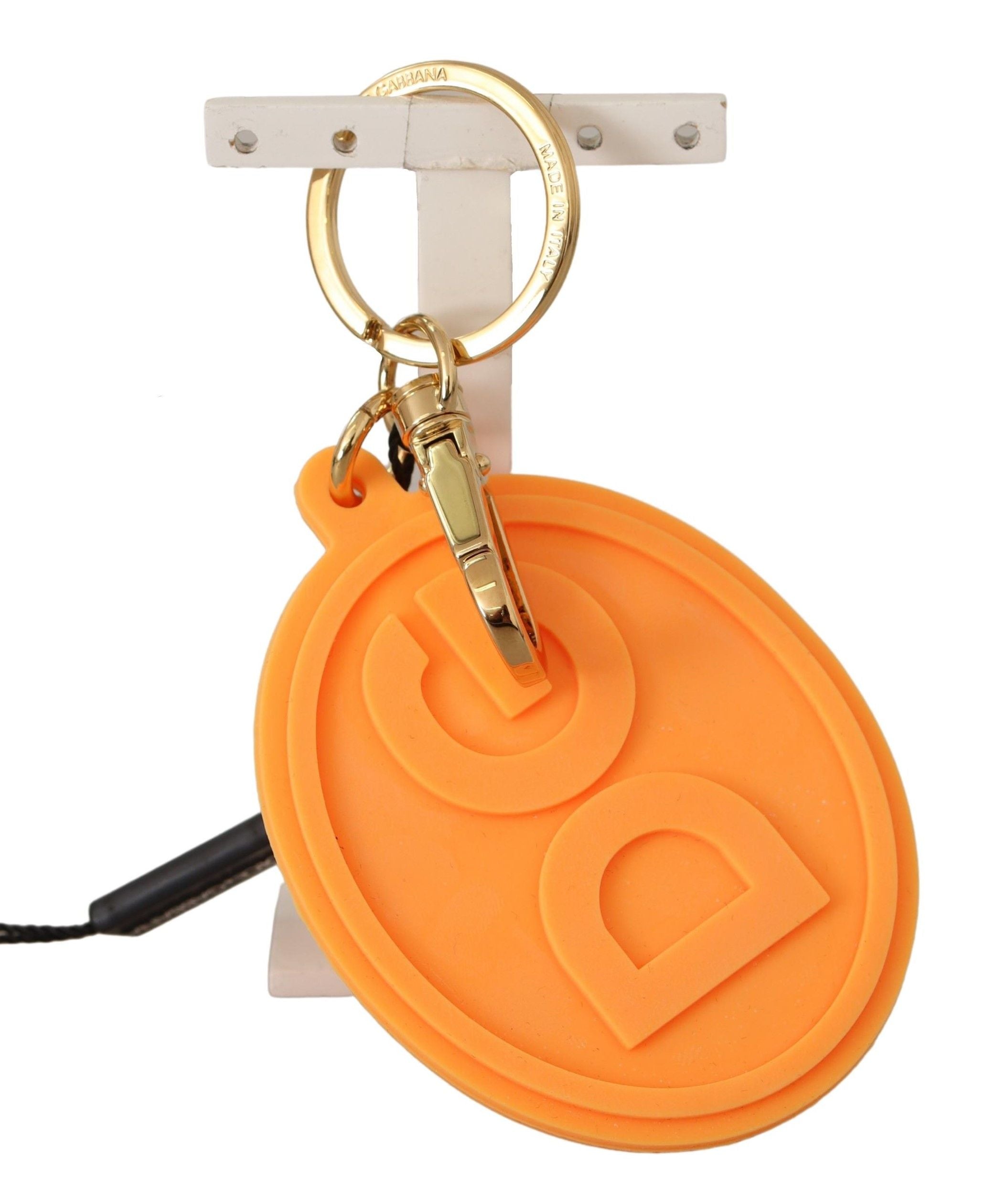 Orangefarbener Gummi-Schlüsselanhänger mit DG-Logo aus goldfarbenem Messing