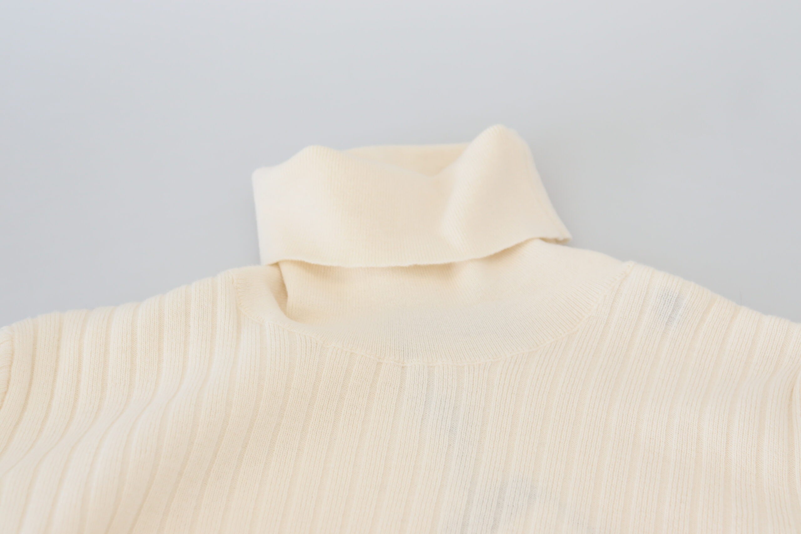 Elfenbeinfarbener Rollkragenpullover mit ausgefransten Ärmelbündchen