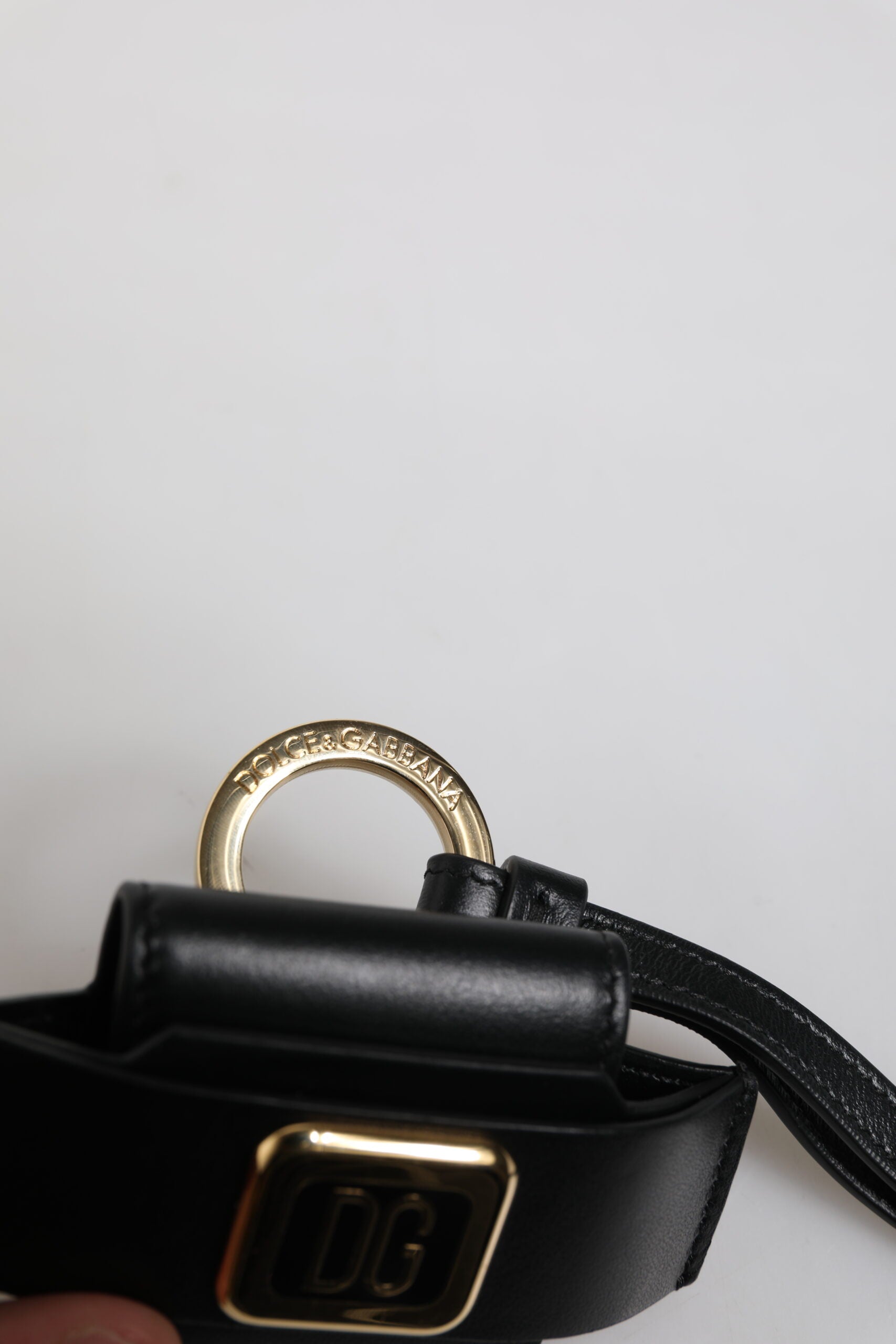 Airpods Hülle aus schwarzem Leder mit goldfarbener Metall-Logo-Plakette